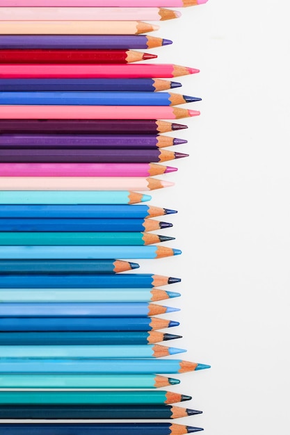 Des crayons multicolores sont posés sur une table blanche. La gamme de couleurs violettes.