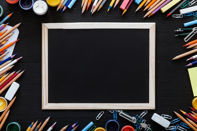 Crayons sur tableau noir, fournitures de papeterie pour l'enseignement de l'enseignement sur un bureau en bois