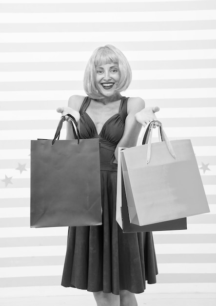 Crazy girl shopping femme heureuse aux cheveux orange tenir achat fille avec des sacs de magasin après une grande vente sur le cyber lundi concept d'avantages fou de shopping femme accro du shopping