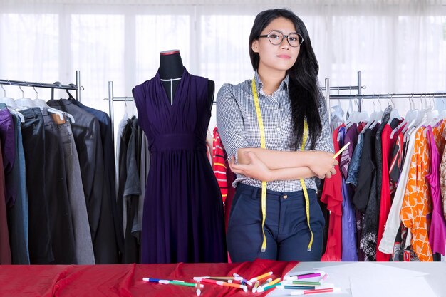 Un créateur de mode asiatique confiant qui croise les bras.