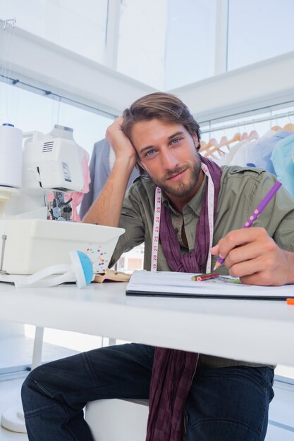 Créateur de mode attrayant travaillant à son bureau