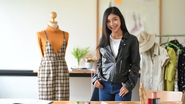 Créateur de mode debout près de mannequin en studio.