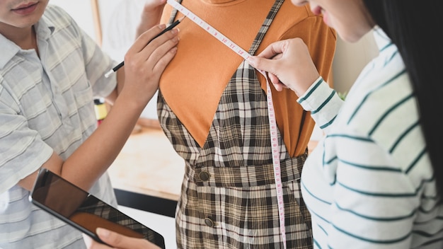 Photo créateurs de mode travaillant sur la mesure de mannequin