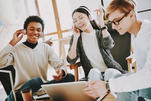 Des créateurs souriants écoutent de la musique au casque