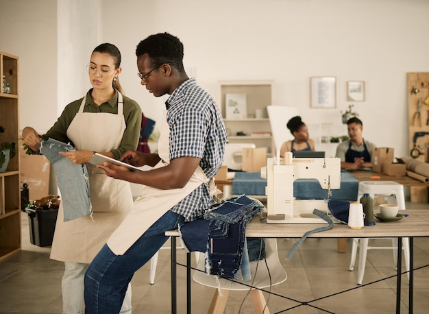 Créateurs de vêtements et de mode travaillant sur de nouveaux modèles de jeans à la mode dans un atelier de denim