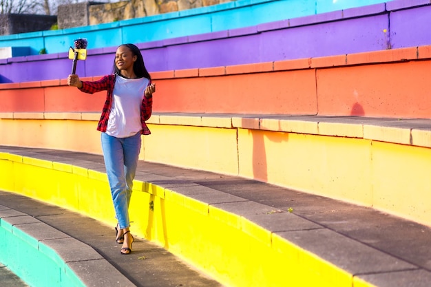 Photo création de contenu africain s'enregistrant elle-même dans un parc urbain coloré