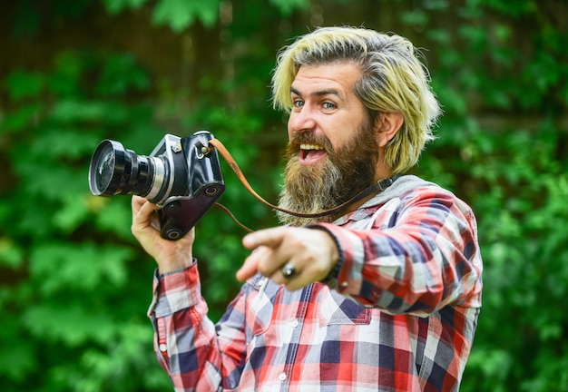 Création de contenu pour le blog Hipster homme barbu prenant une photo La photographie dans la vie moderne Passe-temps et occupation professionnelle Photographe et appareil photo vintage Homme avec appareil photo rétro Utiliser l'appareil photo