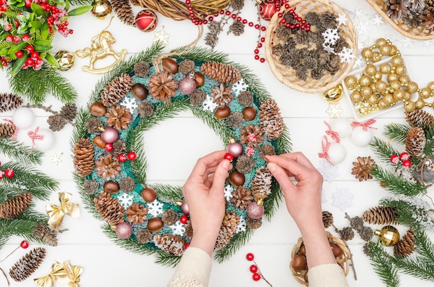 Création étape par étape d'une grande couronne de Noël, étape 14 - collez des baies artificielles sur un fil dans la base