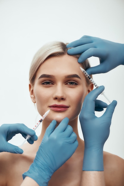 Création d'un portrait de beauté d'une jeune jolie femme regardant la caméra et souriant pendant que les médecins