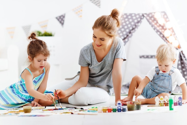 La créativité des enfants mère et enfants dessinent des peintures dans la salle de jeux