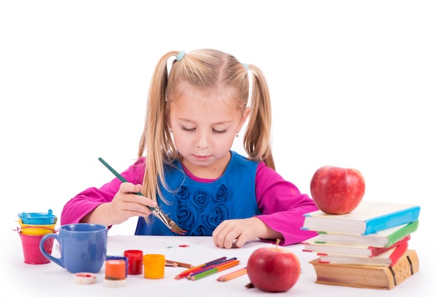 La créativité des loisirs des enfants une petite fille en robe bleue dessine des peintures