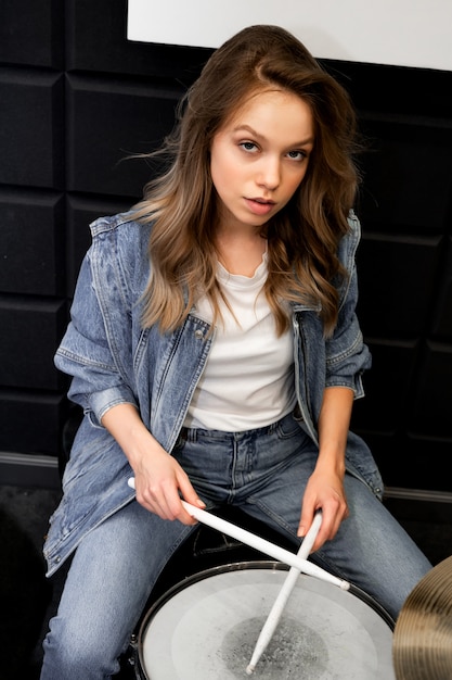 Créativité et musique. Belle jeune fille joue de la batterie. Studio d'enregistrement. Matériel musical.