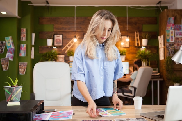 Une créatrice créative vérifiant le motif de sa nouvelle ligne de vêtements dans un bureau de création.