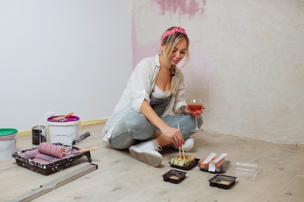 Une créatrice de fille sexy mange des sushis sur le chantier de construction, un peintre déjeune après l'intérieur de workconcept