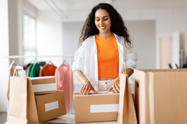 Créatrice de mode femme emballant des boîtes en carton pour la livraison au magasin