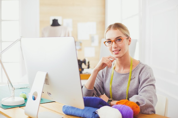 Créatrice de mode femme travaillant en studio assis au bureau