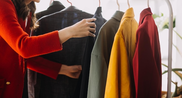 Créatrice de mode l jeune femme asiatique travaillant à l'aide d'une tablette pour ordinateur portable et souriant tout en se tenant dans l'atelier Répondant aux affaires