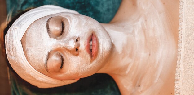 Crème anti-âge appliquée sur le visage du client lors d'une procédure spa au centre de bien-être