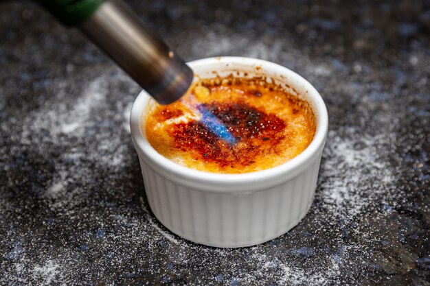 Crème brûlée traditionnelle sur surface rustique et mise au point sélective