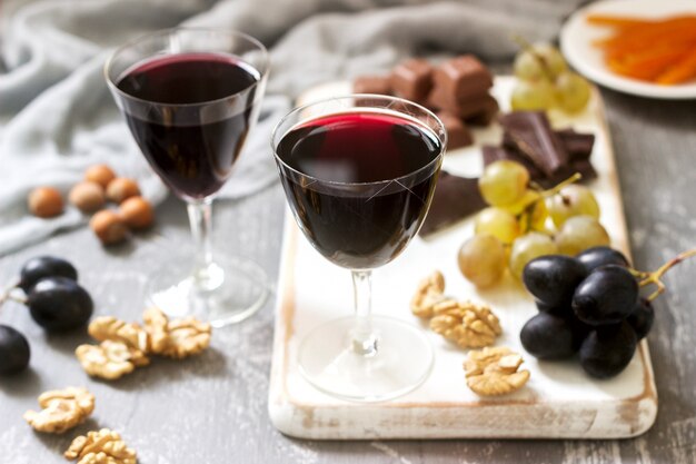 Crème de Cassis liqueur maison servie avec raisins, noix et chocolat