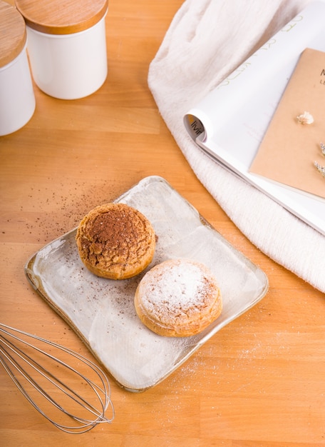 Crème de choux placée sur une assiette, fond en bois marron.