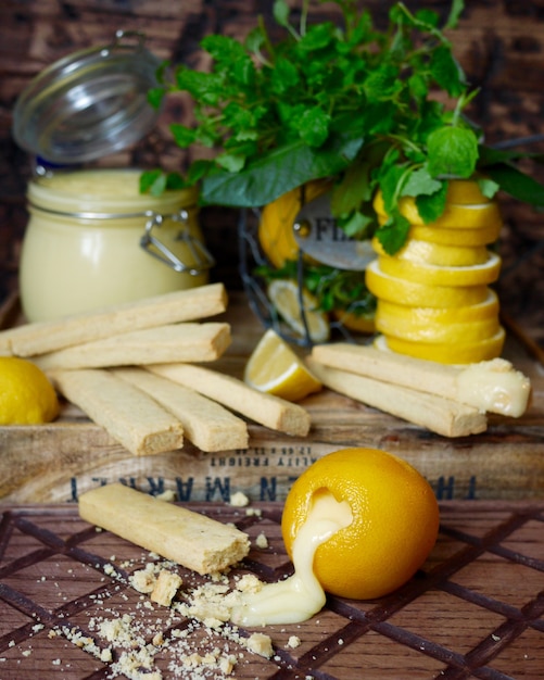 Crème de citron faite maison avec des bâtonnets de sablés et citrons