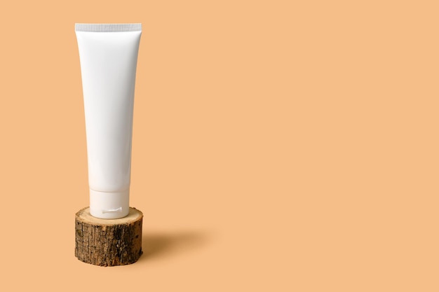 Crème cosmétique blanche sur un podium en bois.