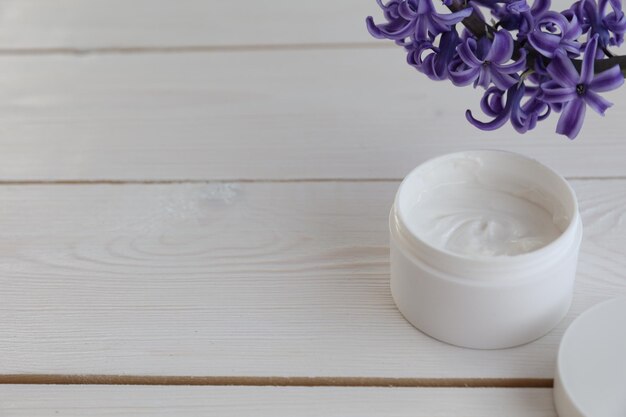 Crème cosmétique et fleur sur fond blanc