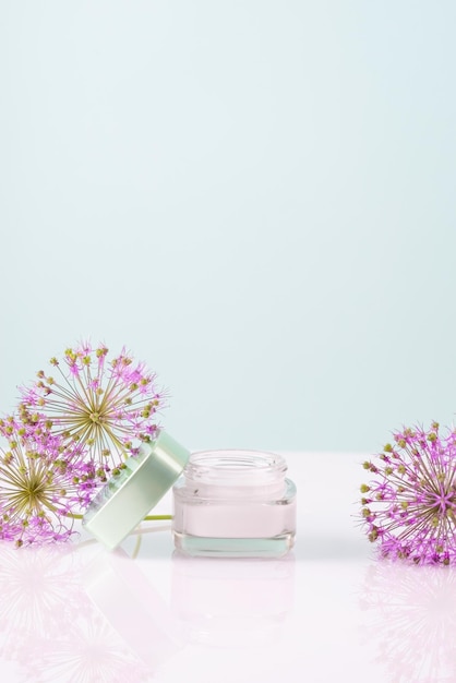 Crème cosmétique avec des fleurs sur fond blanc Soins de la peau du visage et des mains Cosmétique naturelle