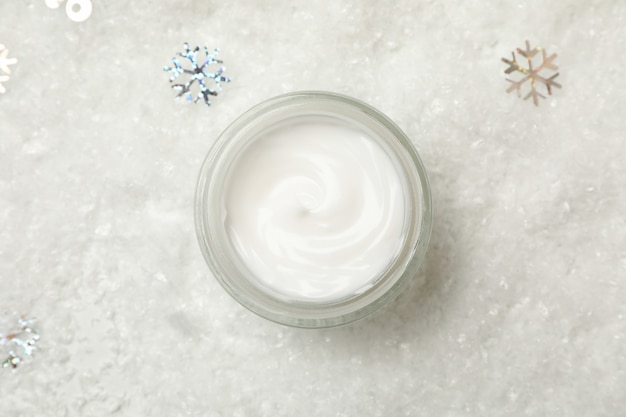 Crème cosmétique sur fond de neige décorative