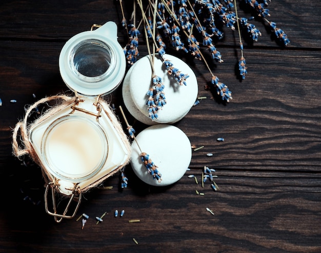 Photo crème dans un pot et lavande sèche sur un fond en bois.