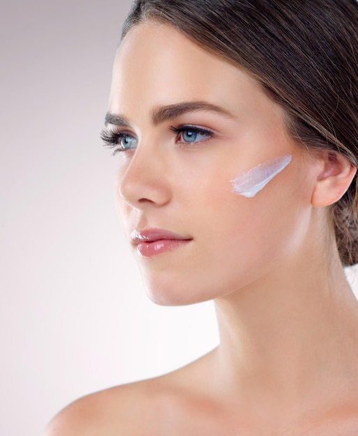 Crème faciale pensante ou femme avec soin de la peau en studio sur fond blanc pour la fondation lueur ou lueur Lotion faciale modèle de fille avec écran solaire idée de beauté ou produits cosmétiques résultats en Allemagne