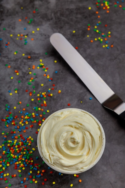 Crème fouettée à la vanille texturée dans un bol avec une spatule.