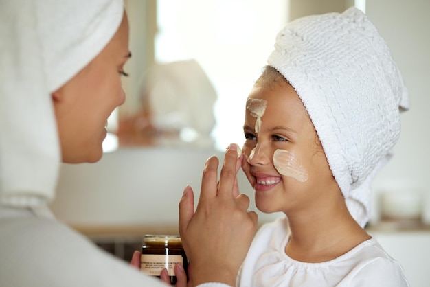 Crème fraîche pour le visage et produit pour la peau saine pour la journée de spa à domicile mère et fille Enfant amusant et ludique et parent appliquant une crème hydratante pour la routine de toilettage ou la protection solaire