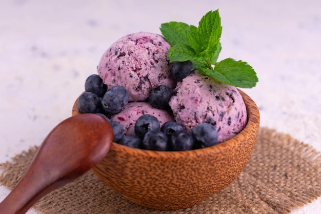 Crème glacée aux bleuets dans un bol rustique à la menthe et aux bleuets sur une assiette blanche