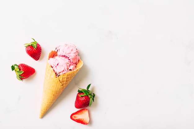 Crème glacée à la fraise rouge et aux fruits dans un cône de gaufre