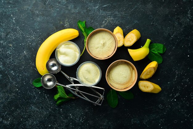 Crème glacée jaune banane à la menthe et à la banane fraîche Cuillère à crème glacée Sur une vue de dessus de fond en pierre noire