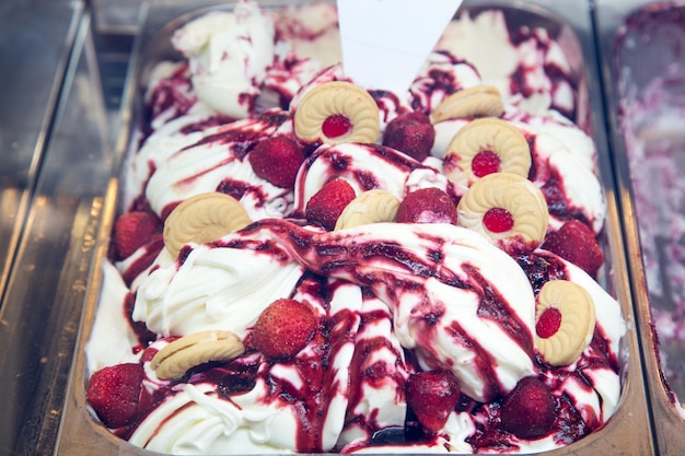 Photo crème glacée maison avec mélange de saveur de yogourt avec sirop de baies et biscuits