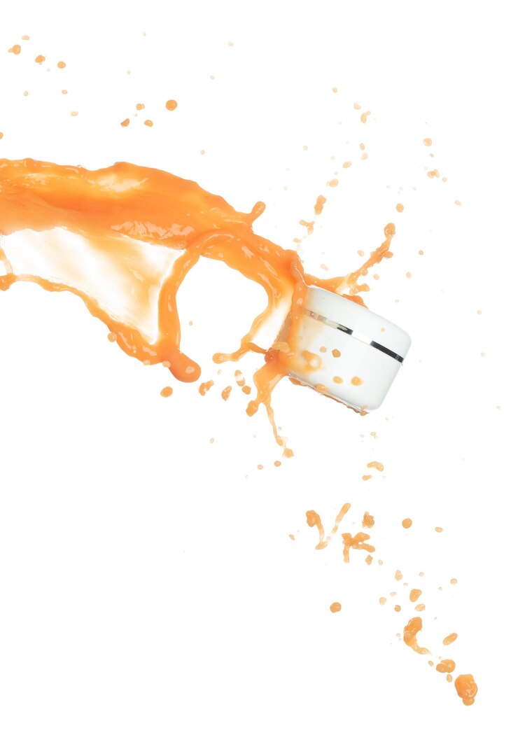 Photo crème hydratante de jus d'orange versée dans un récipient de bouteille cosmétique peinture orange