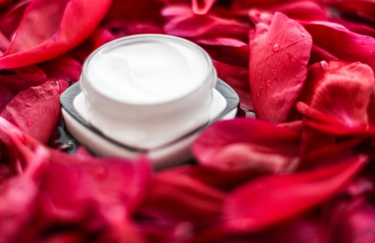 Crème hydratante pour soins de la peau sensible sur pétales de fleurs rouges et fond d'eau sciences naturelles pour la peau