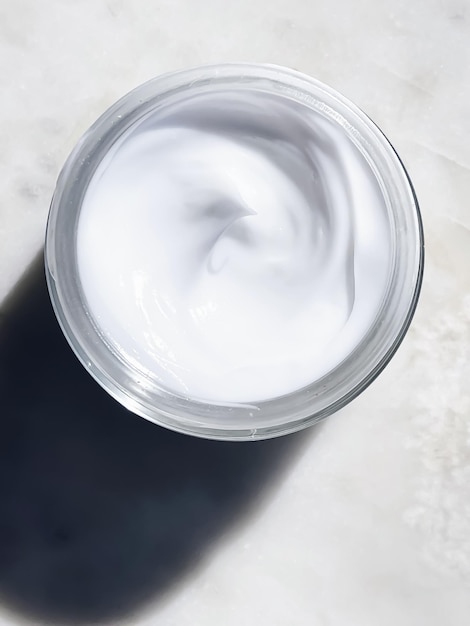 Crème hydratante pour le visage pot en verre sur fond de pierre de marbre concept de produit de soins de la peau et de beauté cosmétique