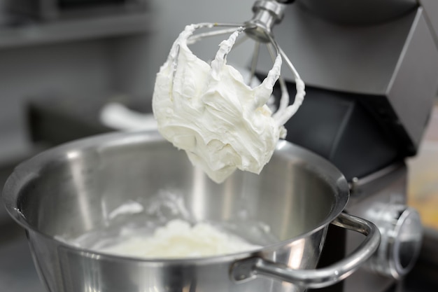 Crème ou meringue sur la corolle du mélangeur de la machine de cuisine