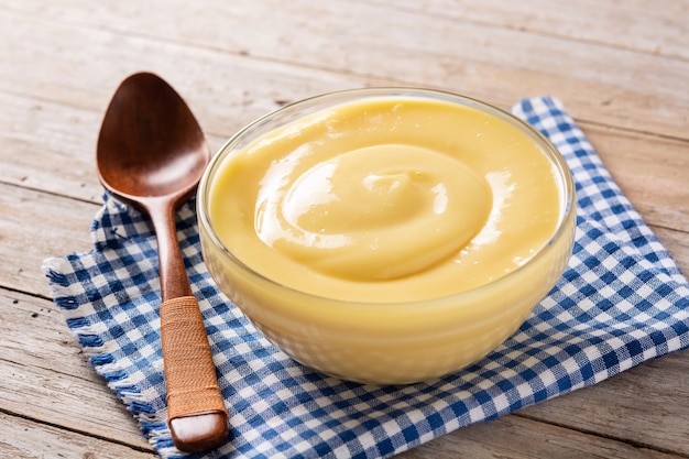 Photo crème pâtissière dans un bol sur table en bois