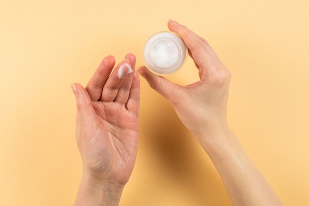 Crème pour les mains et femme mains sur beige