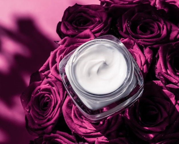 Crème pour le visage hydratant pour la peau sur des fleurs de roses roses produit cosmétique de luxe pour le soin de la peau sur fond floral comme conception de flatlay de vacances de marque de beauté