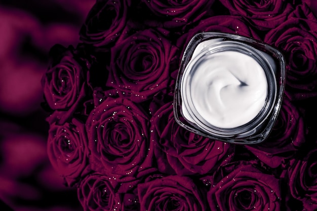 Crème pour le visage hydratant pour la peau et produit cosmétique de luxe pour les fleurs violettes foncées sur fond floral comme conception de flatlay de vacances de marque de beauté