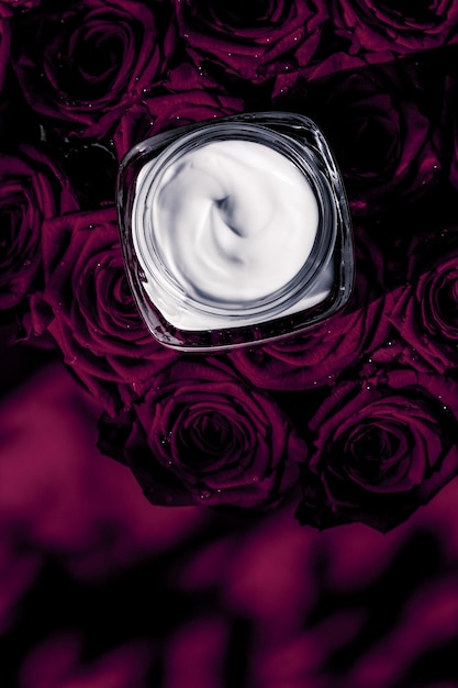 Crème pour le visage hydratant pour la peau et produit cosmétique de luxe pour les fleurs violettes foncées sur fond floral comme conception de flatlay de vacances de marque de beauté