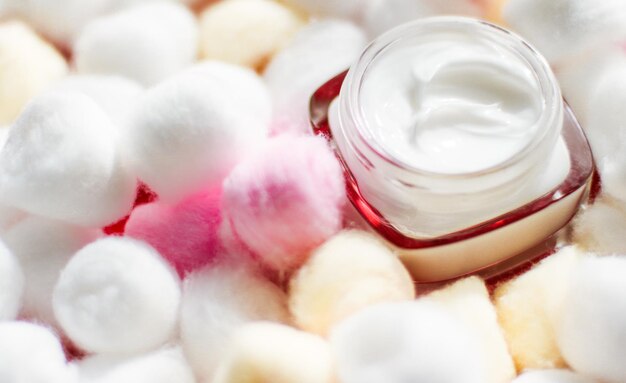 Photo crème pour le visage de luxe pour les peaux sensibles et les boules de coton écologiques sur les cosmétiques de spa de fond et le produit naturel de marque de beauté de soins de la peau