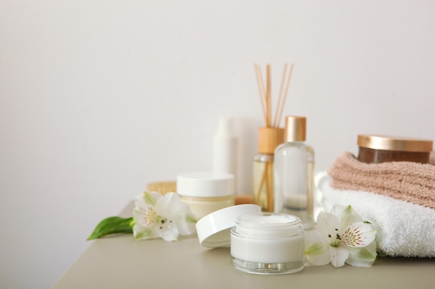 Crème de soin et fleurs sur les cosmétiques de table pour les soins de la peau