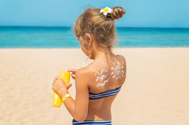 Crème solaire sur la peau d'un enfant. Mise au point sélective. la nature.